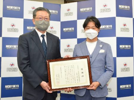 さぽうと21の小松博史理事（左）から感謝状を受ける西村拓郎会長（右）