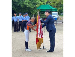 優勝旗を返還する前回優勝チーム（右：新田会長）