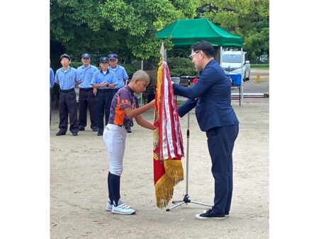 優勝旗を返還する前回優勝チーム(右:新田会長)